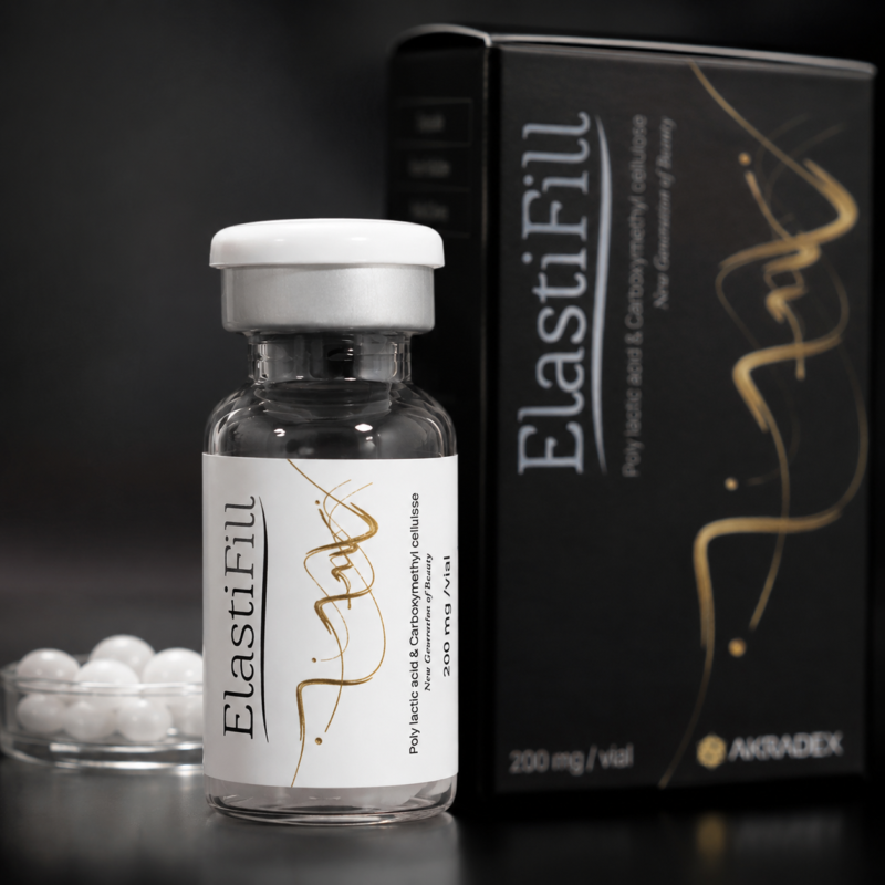 Close-up of ElastiFill vial with AKRADEX black packaging and white pellets in the background